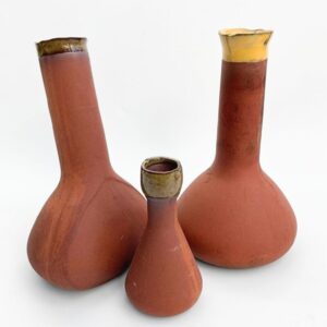 Handmade terracotta olla buried in soil, providing slow-release irrigation for sustainable plant care.