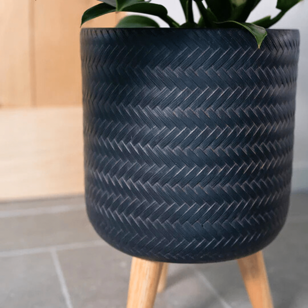 Fenne woven planter 2 Fenne woven planter on legs in dry green and black, handcrafted from sustainable materials for indoor use