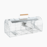 Multi-Catch and Release Rat Trap with dual entry points, shown placed in a garden area for humane rodent control.
